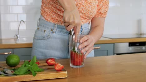 Woman-Making-Cocktail-Drinks-at-Home-Kitchen.drinks-and-people-concept--young-woman-making-strawberry-mojito-cocktail-at-home-kitchen