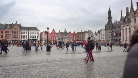 Wide-shot-of-Bruges'-main-square,-the-Market-Square,-while-many-tourists-walk-around