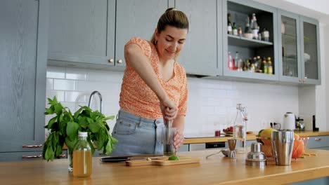 Woman-Making-Cocktail-Drinks-at-Home-Kitchen.drinks-and-people-concept--young-woman-making-strawberry-mojito-cocktail-at-home-kitchen