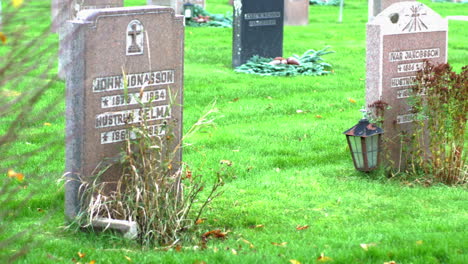 A-shared-grave-by-a-couple-in-Kviberg-Cemetery-in-Gothenburg,-Sweden---close-up-panning