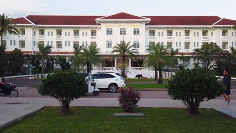 View-of-Raffle-hotel-in-bright-sunny-day-with-a-beautiful-public-garden-in-the-front