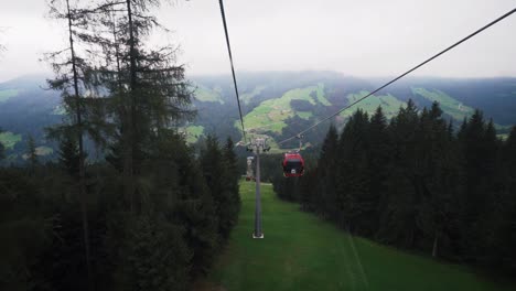 Vista-Panorámica-De-Las-Montañas-Al-Fondo,-Alejándose-Del-Teleférico-Rojo-En-Auffach,-Austria