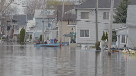 People-moving-through-a-flooded-neighbouhood-in-a-motorboat