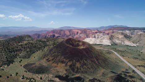 Drone-pushing-out-from-an-inactive-volcano-with-a-large-round-crater-in-the-mountains