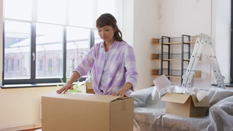 Women-with-Adhesive-Tape-Packing-Boxes-at-Home.moving,-people-and-real-estate-concept--women-with-adhesive-tape-packing-boxes-at-home