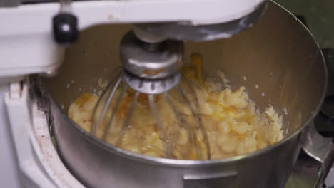 Eggs-added-to-cookie-dough-machine,-slow-motion-1080p