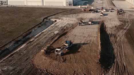 As-a-dump-truck-readies-to-drop-a-load-of-soil,-a-Multi-Terrain-Loader-pushes-and-spreads-the-soil-out