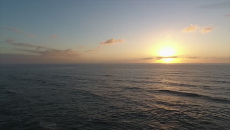 Sunrise-at-ocean-with-rocks,-aerial-footage