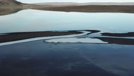 Majestic-Landscape-of-Iceland,-Drone-Aerial-View-of-Shallow-Glacial-Lake-and-Sky-Mirror-Reflection