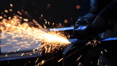 the-concept-for-safety-first,-Close-up-of-a-man-worker-cutting-metal-with-a-hand-held-circular-saw-with-a-yellow-handle-in-the-workshop,-in-the-background-a-lot-of-generalization-1