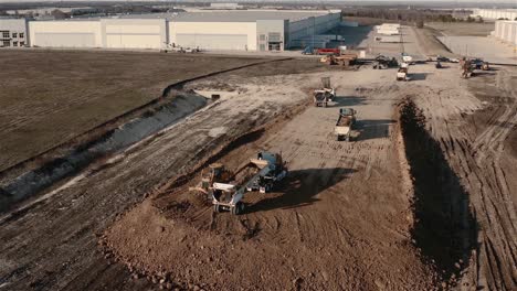 A-tractor-pushed-dirt-over-the-edge-as-a-dump-truck-waits-to-dump-a-new-load-of-dirt