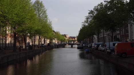 Slider-shot-of-canal-in-the-Netherlands,-with-a-bicycle-wheel-in-the-forefront