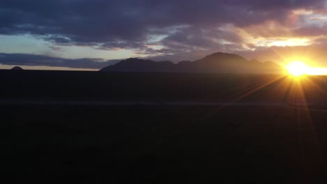 El-Dron-Se-Eleva-Desde-Debajo-De-La-Presa-Para-Revelar-El-Sol-Brillando-Sobre-El-Lago.