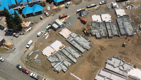 Aerial-shot-of-new-construction-townhome-site-with-smooth-rotation-and-pitch-movement-showing-framed-buildings-and-exposed-foundations