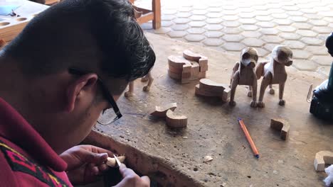 Un-Artesano-Detallando-Algunas-Partes-De-Madera-De-Esculturas.