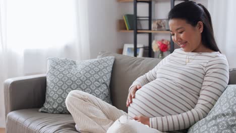 Feliz-Mujer-Asiática-Embarazada-Con-Computadora-Portátil-En-Casa.-Concepto-De-Embarazo,-Descanso,-Personas-Y-Expectativas-Feliz-Sonriente-Mujer-Asiática-Embarazada-Con-Computadora-Portátil-Sentada-En-Un-Sofá-En-Casa