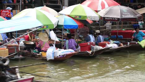 Amphawa,-Thailand---Boats-With-Umbrellas-Selling-Fresh-Raw-Foods-In-The-Floating-Market,-Boat-Service-With-Passengers-Passes-By---Close-up-Shot