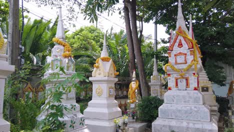 Ornate-Thai-Buddhist-tombstones.-Handheld,-pan-right