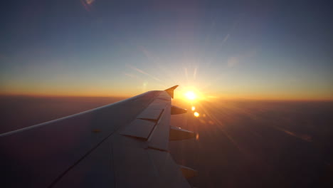 Traveling-by-plane-with-the-bright-sun-setting-in-the-horizon---Mid-shot