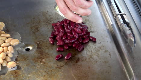 Healthy-beans-and-legumes-being-cooked-on-large-frying-pan,-fixed-close-up