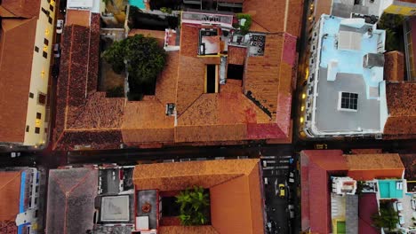 Aerial,-top-down,-drone-shot-descending-above-traffic-on-streets-of-Cartagena-city,-sunny-evening,-in-Colombia,-South-America