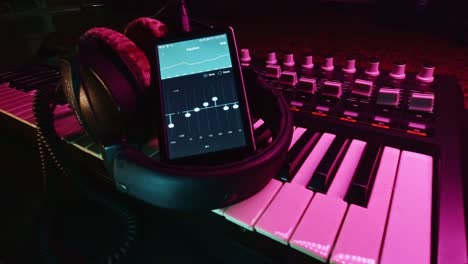 Dolly-shot-of-Digital-Audio-Player-with-professional-headphone-on-a-midi-controller