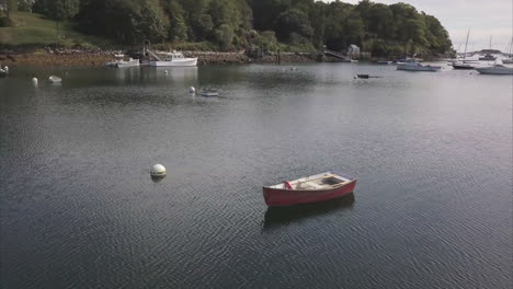 A-lone-boat-sitting-in-Rockport-Harbor,-Maine-AERIAL