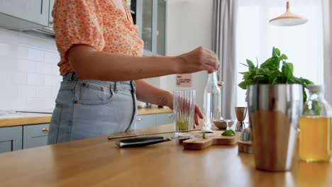 Woman-Making-Cocktail-Drinks-at-Home-Kitchen.drinks-and-people-concept--young-woman-making-strawberry-mojito-cocktail-at-home-kitchen