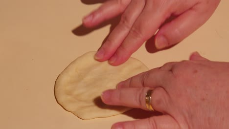 Mature-woman-hands-kneading-raw-dough-in-slow-motion