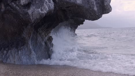 Hermosa-Vista-De-Las-Olas-Golpeando-Un-Acantilado-En-La-Costa-De-Una-Isla-Tropical-En-Cámara-Lenta-Durante-El-Día.