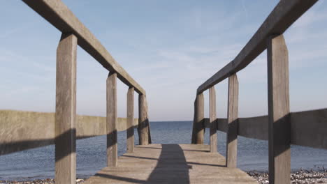 Walking-up-steps-to-reveal-a-bridge-to-the-beach-of-the-Baltic-sea