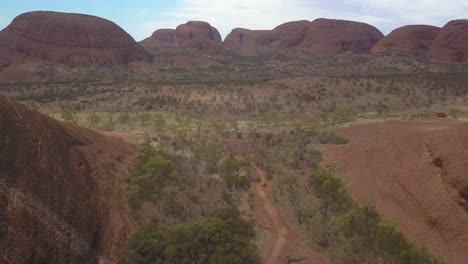 Uluru-Ayres-Rock-Australia,-drone-tilt-down-shot-to-reveal-Kuniya-walking-track