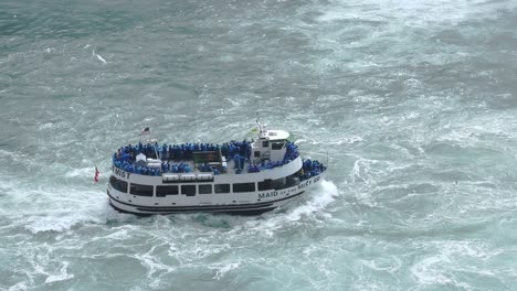 El-Barco-Blue-Maid-Of-The-Mist-Se-Desplaza-Contra-La-Corriente-Bajo-Las-Cataratas-Del-Niágara,-Vista-Aérea