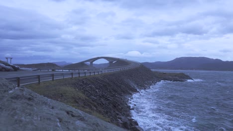 Waves-crashing-upon-shore-next-to-shore-as-car-passes-by