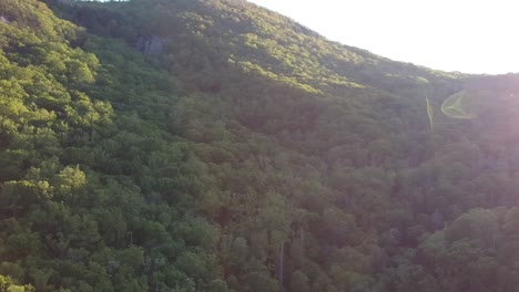 Push-in-shot-of-a-mountainside-at-sunset-with-a-lens-flare