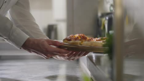 Nearby-a-waiter-in-a-long-white-shirt-takes-ready-made-dishes-with-his-own-hands-and-takes-them-away-to-take-them-to-the-customer.-While-the-cook-puts-out-a-new-ready-made-dish-and-notifies-with-a-bell