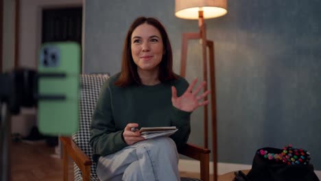 A-happy-brunette-girl-runs-her-blog-using-a-green-phone-and-writes-at-home-in-an-atmospheric-cozy-apartment