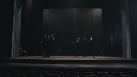 Dos-Parejas-De-Actores-Activos-Con-Trajes-Negros-Bailan-Su-Baile-Lento-En-El-Escenario-Durante-La-Preparación-Para-Una-Actuación-Y-Un-Ensayo-En-Un-Teatro-Vacío.