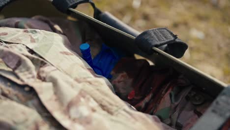 Close-up-of-an-unconscious-male-soldier-in-camouflage-clothing-lies-on-an-army-wear-with-a-bandaged-wounded-hand-during-combat-operations-in-the-steppe-outside-the-city