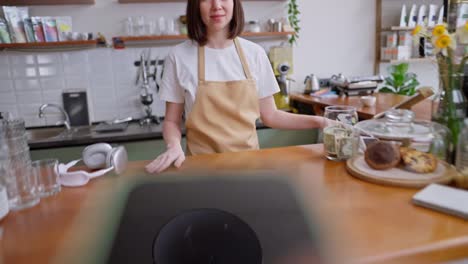 Close-up-from-the-first-person-a-guy-brings-his-phone-to-the-terminal-which-is-brought-by-a-brunette-waitress-girl-behind-the-counter-to-pay-in-a-cafe