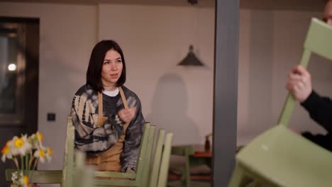 A-brunette-girl-waiter-yawns-while-cleaning-the-hall-of-a-cafe-together-with-her-colleague-guy