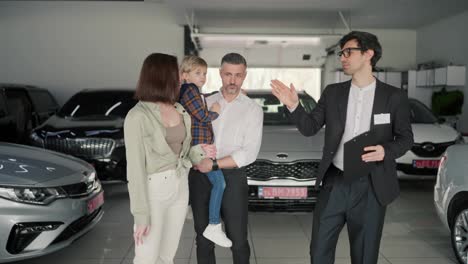 A-family-of-a-middle-aged-man-his-wife-and-little-son-came-to-a-car-dealership-and-talked-with-an-assistant-in-a-business-suit-about-what-cars-were-available-and-about-the-cars-in-a-modern-car-dealership