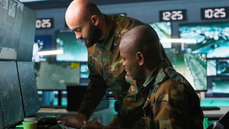 Military-dispatcher-helped-by-coworker-with-tablet