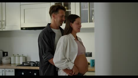 Feliz-Hombre-De-Mediana-Edad-Bailando-Con-Su-Esposa-Embarazada-En-La-Cocina.-Feliz-Pareja,-Marido-Y-Mujer,-Esperando-Un-Bebé-Y-Bailando-En-La-Cocina.