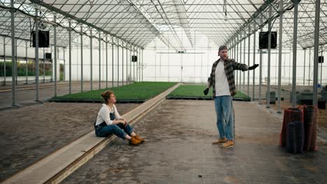 Confident-guy-Farmer-in-a-cap-tells-his-girlfriend-with-red-hair-How-they-will-arrange-a-greenhouse-on-the-farm