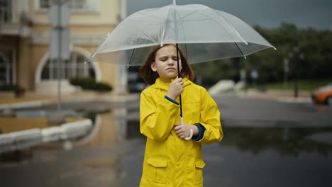 Trauriges-Teenager-Mädchen-In-Einer-Gelben-Jacke-Steht-Und-Hält-Einen-Regenschirm-In-Den-Händen-In-Einem-Windigen-Park-Nach-Dem-Regen