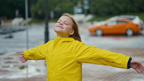 Ein-Glückliches-Blondes-Teenager-Mädchen-Steht-Vor-Dem-Wind,-Lächelt-Und-Posiert-Und-Genießt-Den-Wind-Nach-Dem-Regen-Im-Park