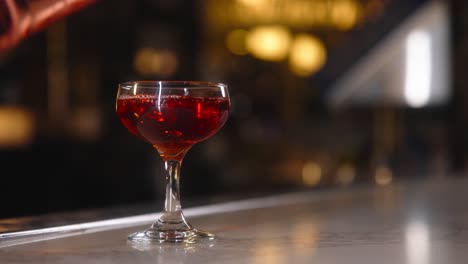 Barman-pouring-beverage-in-a-glass-at-a-restaurant