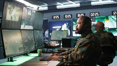 Military-dispatcher-managing-communications-networks,-looking-at-screens