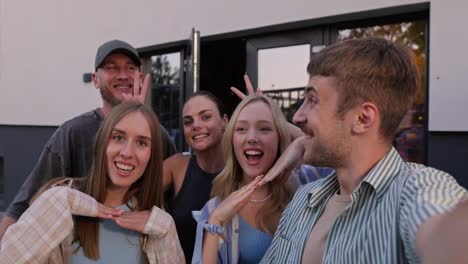 Happy-group-of-friends-posing-and-taking-a-group-selfie-in-the-courtyard-of-a-country-house-during-their-vacation